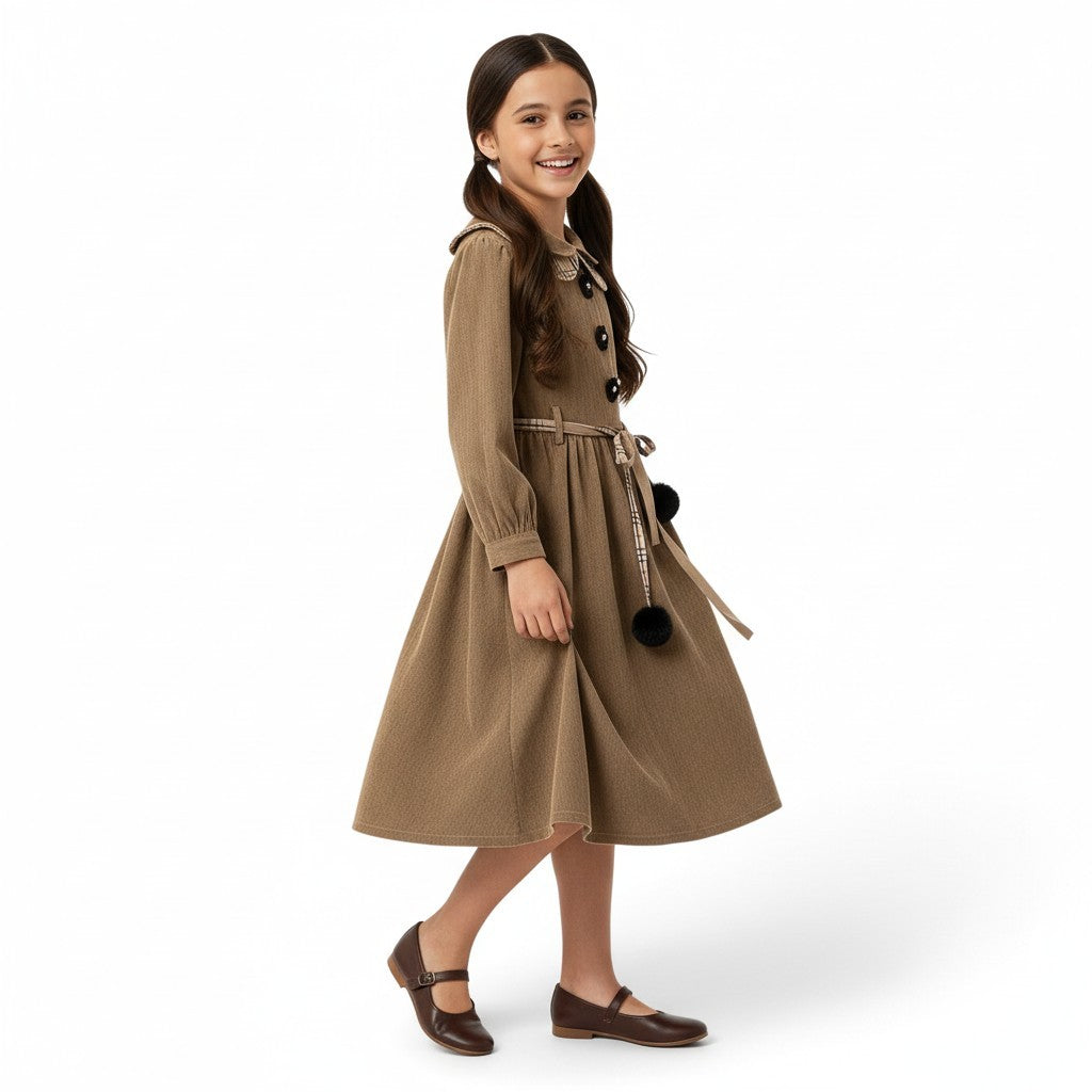 JOANNA FASHION long sleeve brown dress with Peter Pan collar, floral buttons, and pom-pom tie belt on a young girl.