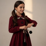 JOANNA FASHION long sleeve burgundy dress with Peter Pan collar, floral buttons, and pom-pom tie belt on a young girl