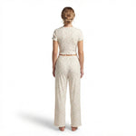 Back view of a woman wearing a JOANNA FASHION soft cream cotton blend pajama set with a floral print and frilled edges