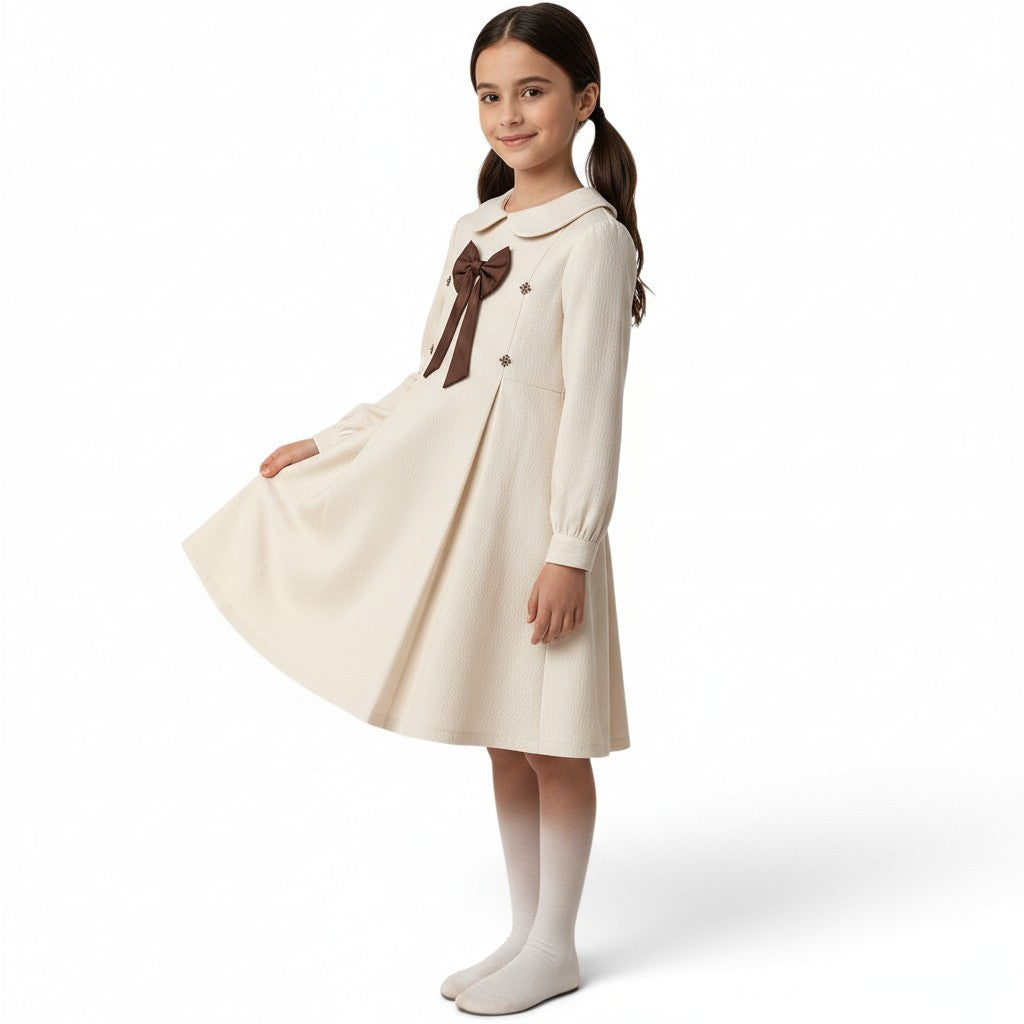JOANNA FASHION cream long-sleeve dress with Peter Pan collar, brown bow, and textured A-line skirt on a young girl