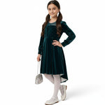 JOANNA FASHION girl in a deep emerald green velvet high-low dress with sparkling bodice and pearl-trimmed neckline.