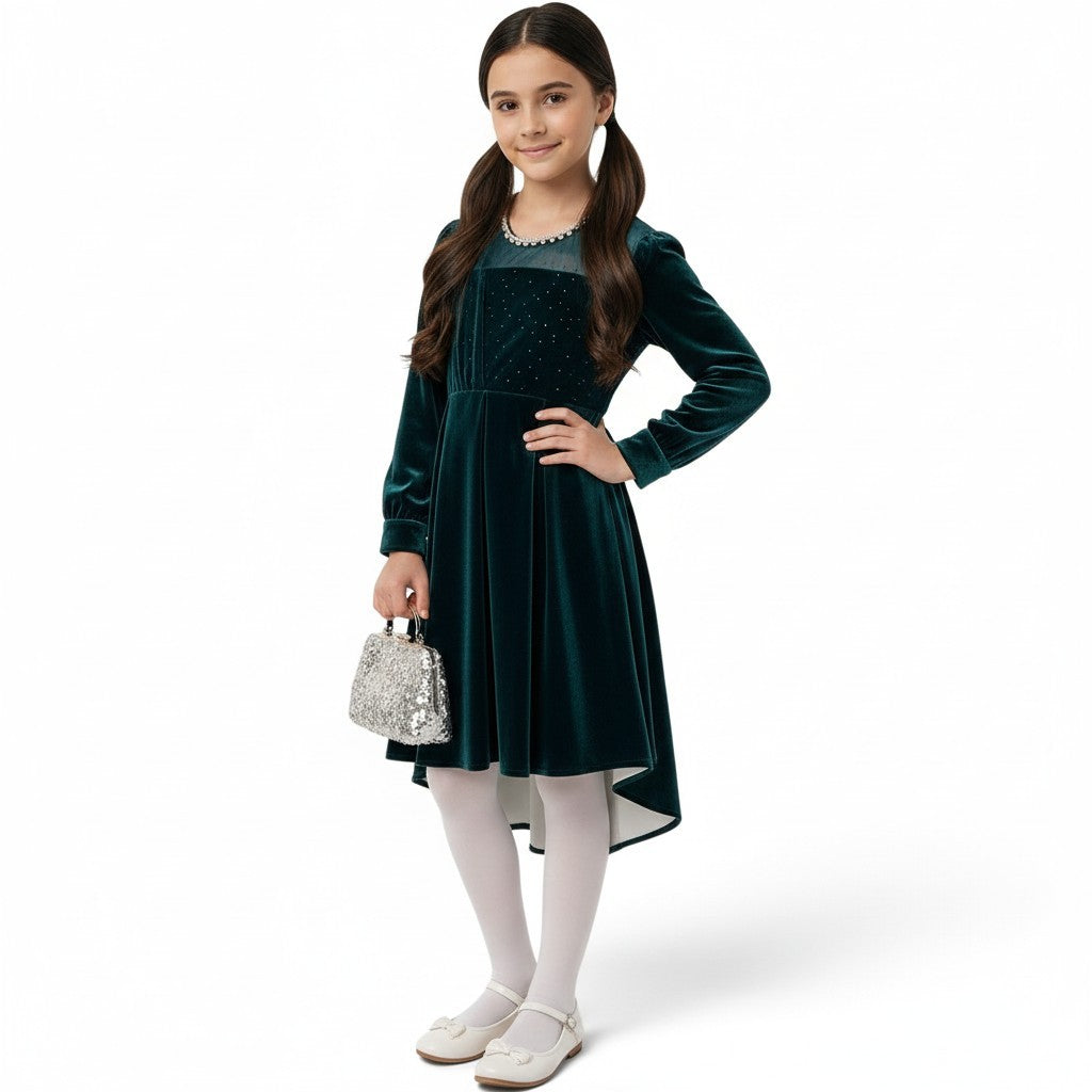 JOANNA FASHION girl in a deep emerald green velvet high-low dress with sparkling bodice and pearl-trimmed neckline.