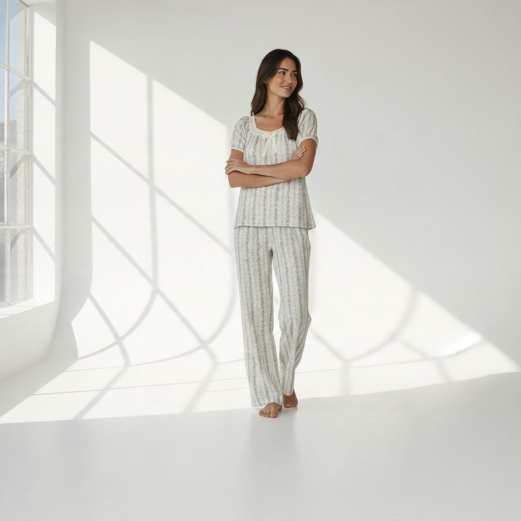 JOANNA FASHION floral pajama set with puff sleeves, lace trim, and ribbon bow on a woman in a bright studio setting.