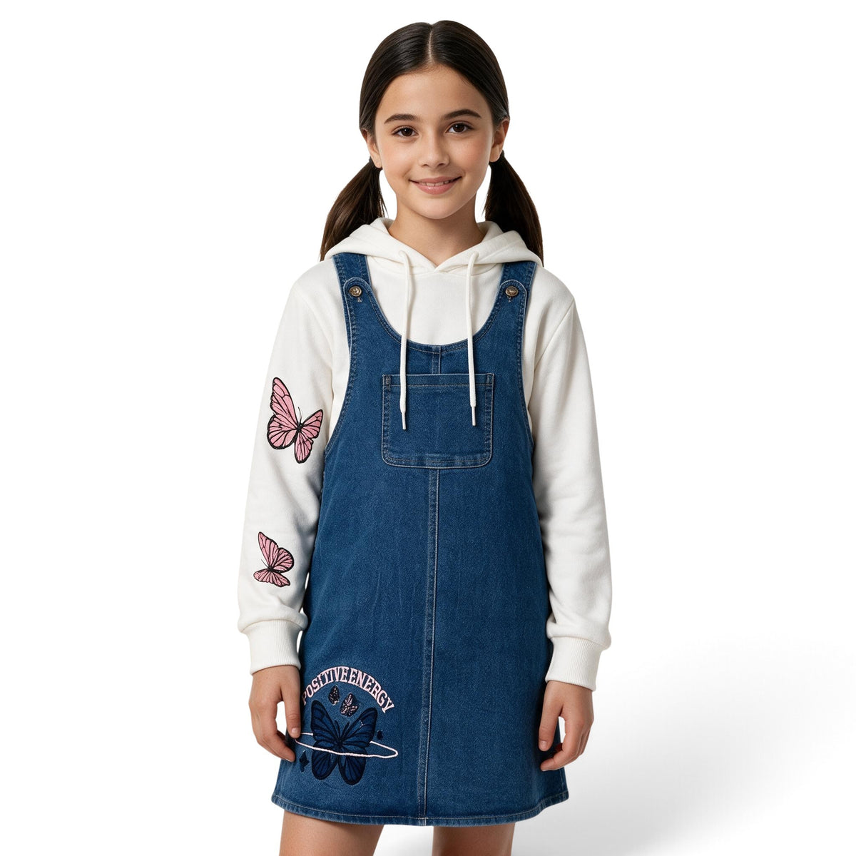 JOANNA FASHION girls blue denim pinafore dress worn over a white hoodie with pink butterfly sleeve graphics