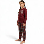 Young girl wearing a JOANNA FASHION burgundy henley long-sleeve rugby pajama top and plaid bottoms with ribbed cuffs.