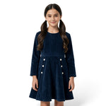 A young girl wearing a JOANNA FASHION navy blue long-sleeve corduroy dress with white button details at the waist.