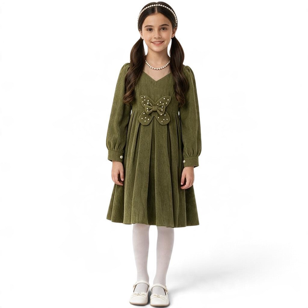 JOANNA FASHION girl wearing an olive green corduroy long sleeve pleated dress with a pearl butterfly waist accent.