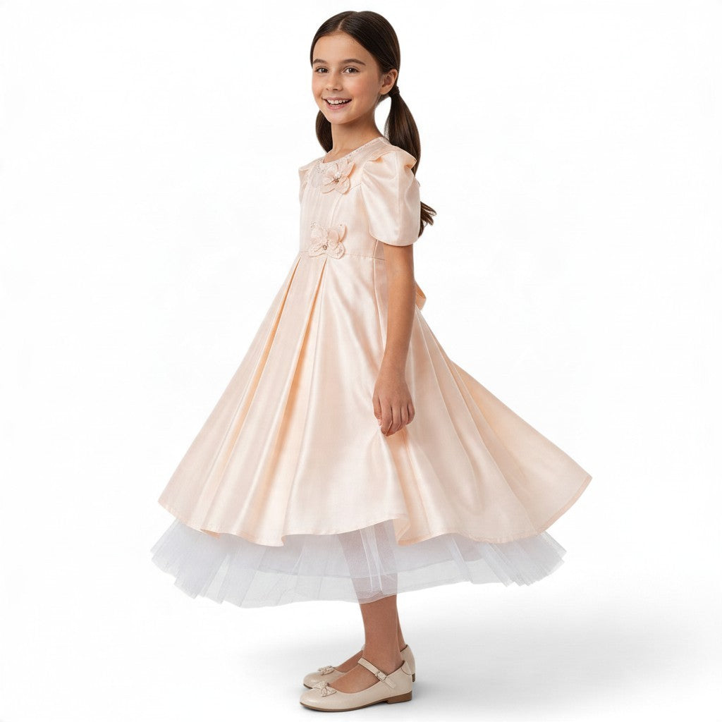 JOANNA FASHION girl wearing a peach satin formal dress with puff sleeves, pearl accents, and a white tulle underskirt.