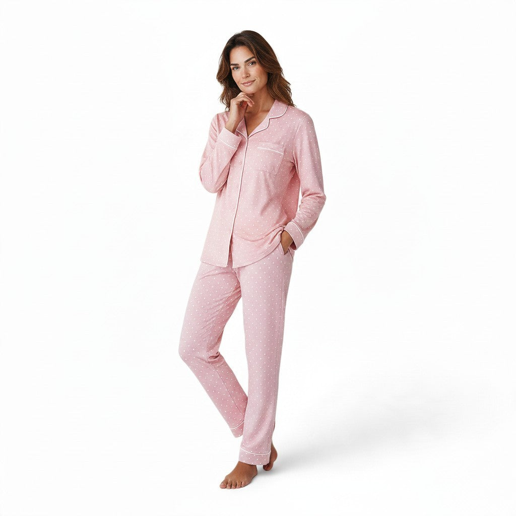 A woman wearing a JOANNA FASHION pink polka dot button-down pajama set with white contrast piping and notched collar.