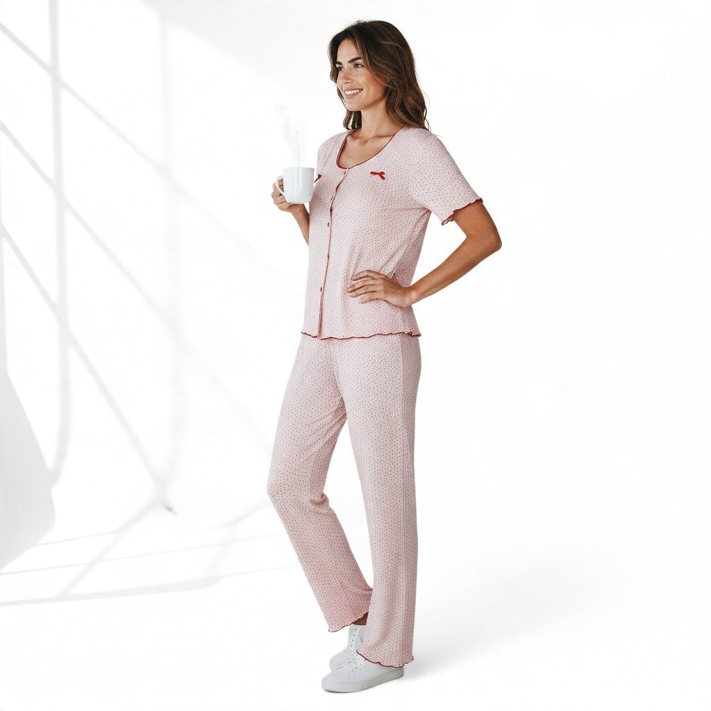 JOANNA FASHION pink polka dot pajama set with button-down top, lettuce-edge trim, and bow accents on a smiling woman.