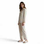 A woman wearing a JOANNA FASHION speckled print button-down pajama set with contrasting piping and matching trousers.