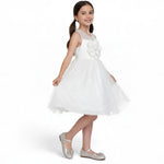 JOANNA FASHION white sleeveless flower girl dress with a sheer neckline, floral applique, and layered tulle skirt.