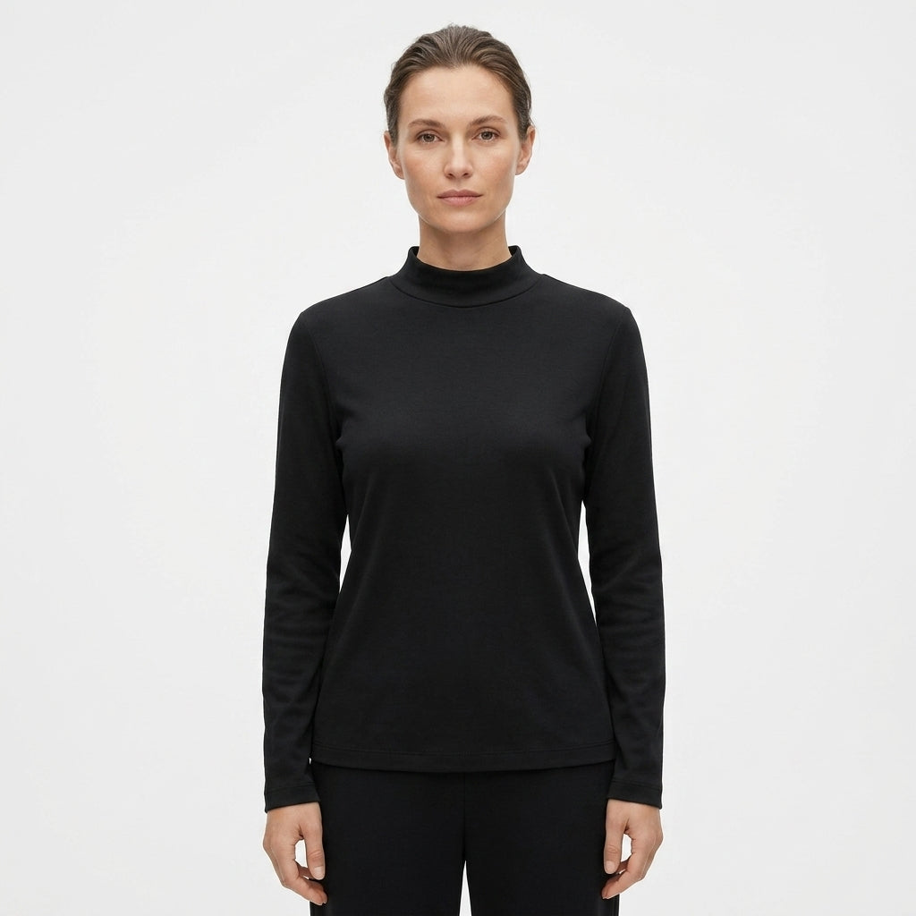 A woman modeling a black long-sleeve mock neck top against a plain white studio background.