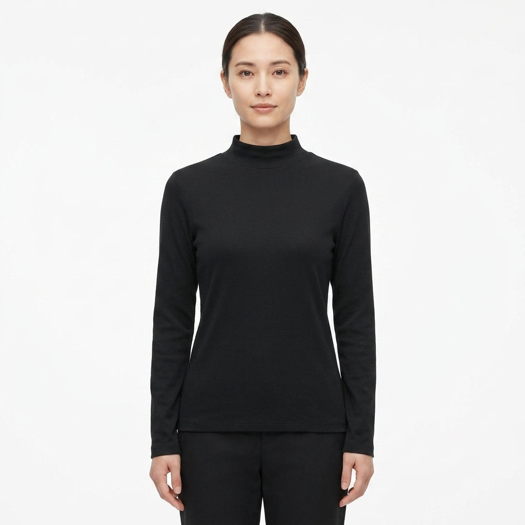 A woman modeling a black long-sleeve mock neck top against a plain white studio background.