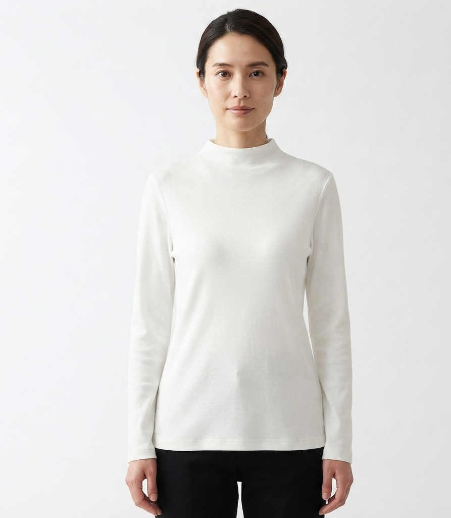 A woman modeling a fitted, long-sleeve mock neck top in off-white, paired with black pants, against a plain white studio background.