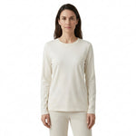 A woman modeling a long-sleeve crewneck top in a warm off-white or cream color, paired with matching pants, against a plain white background.