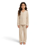 A young girl wearing a JOANNA FASHION beige two-piece pajama set with button-down top and scalloped lace trim.