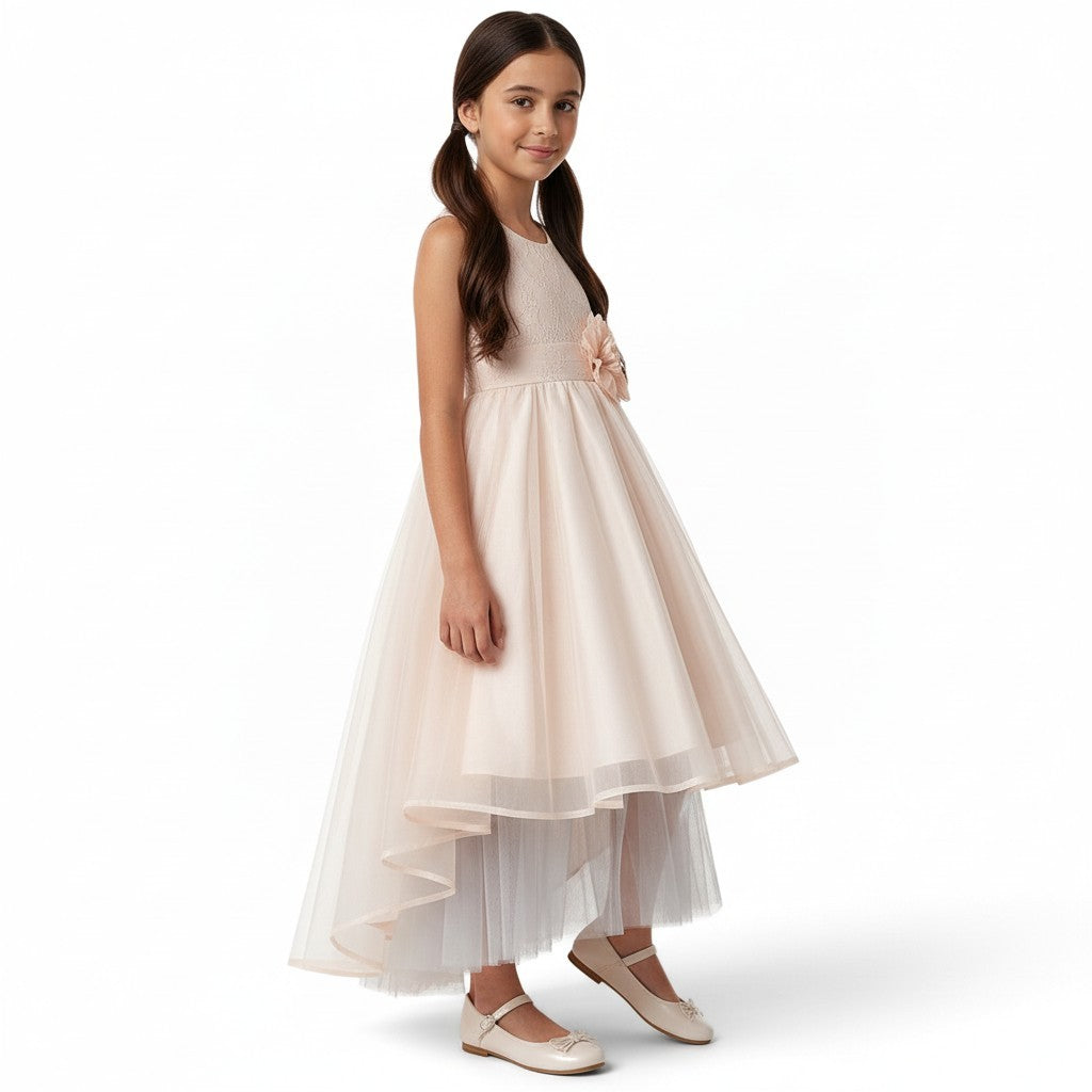 JOANNA FASHION girl wearing a blush pink sleeveless formal dress with lace bodice, floral waist, and high-low tulle skirt