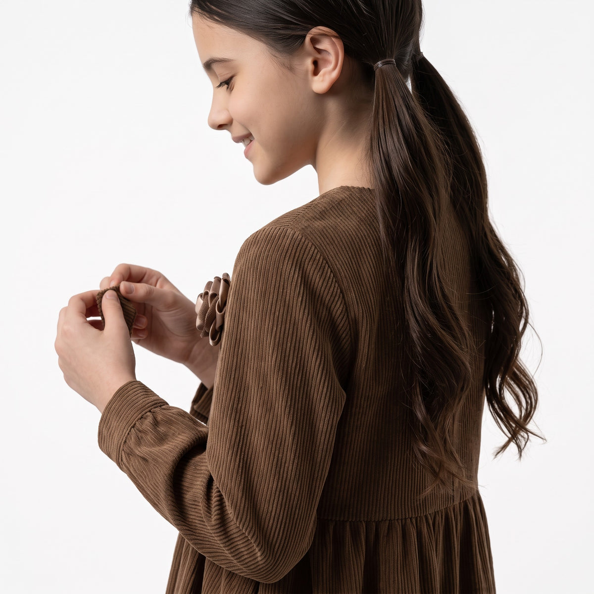 JOANNA FASHION brown corduroy long sleeve dress with floral appliqué on a young girl in profile view