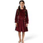 A young girl wearing a JOANNA FASHION long-sleeve burgundy corduroy dress with white button accents at the waist.