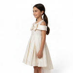 JOANNA FASHION cream formal dress for girls with off-the-shoulder sleeves, sparkling bodice, and large chest bow.