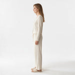 Model wearing a JOANNA FASHION cream ribbed long sleeve lounge set with lettuce-edge trim and wide-leg trousers.