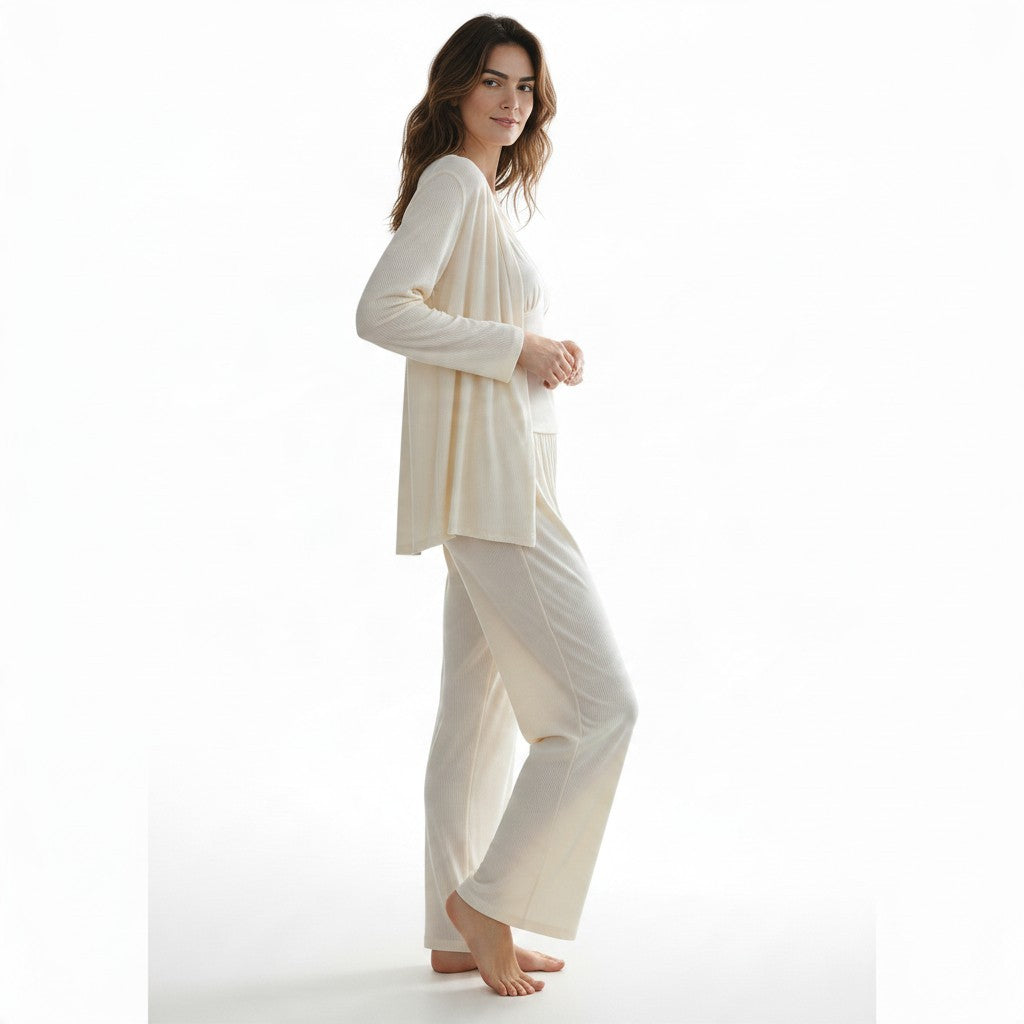A woman wearing a JOANNA FASHION three-piece cream ribbed loungewear set with a cardigan, camisole, and wide-leg pants.