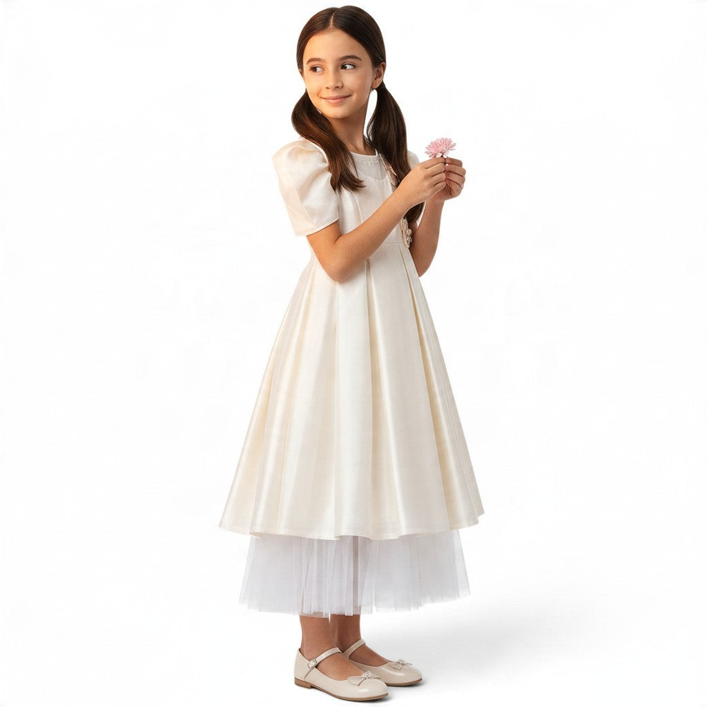 JOANNA FASHION girl wearing a cream satin formal dress with puff sleeves, pearl neckline, and layered tulle hem.