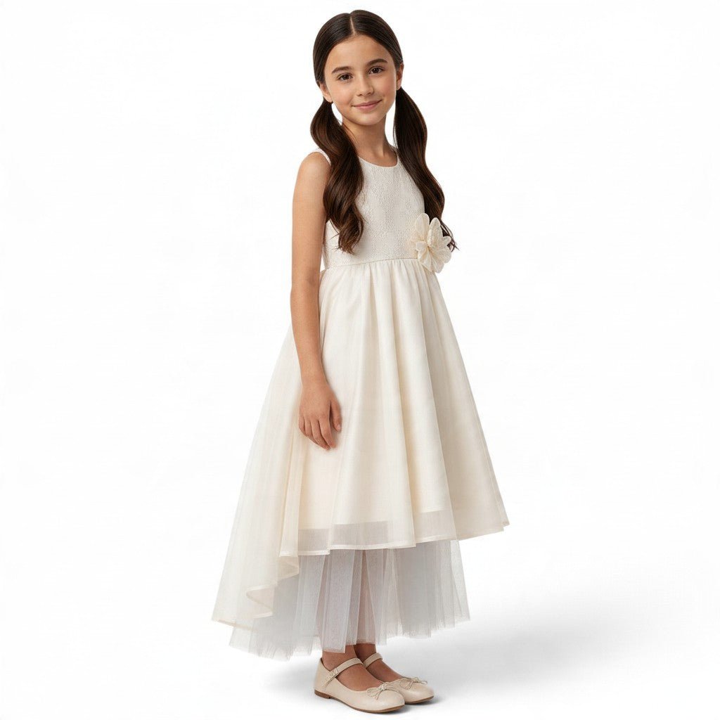 JOANNA FASHION girl in a cream high-low formal dress with lace bodice, floral waist accent, and layered tulle skirt.
