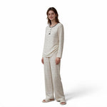 A woman wearing a JOANNA FASHION long sleeve pajama set in cream with a delicate floral print and button-down detail.