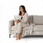JOANNA FASHION three-piece floral pajama set with lace trim, worn by a woman sitting on a sofa with a throw blanket.