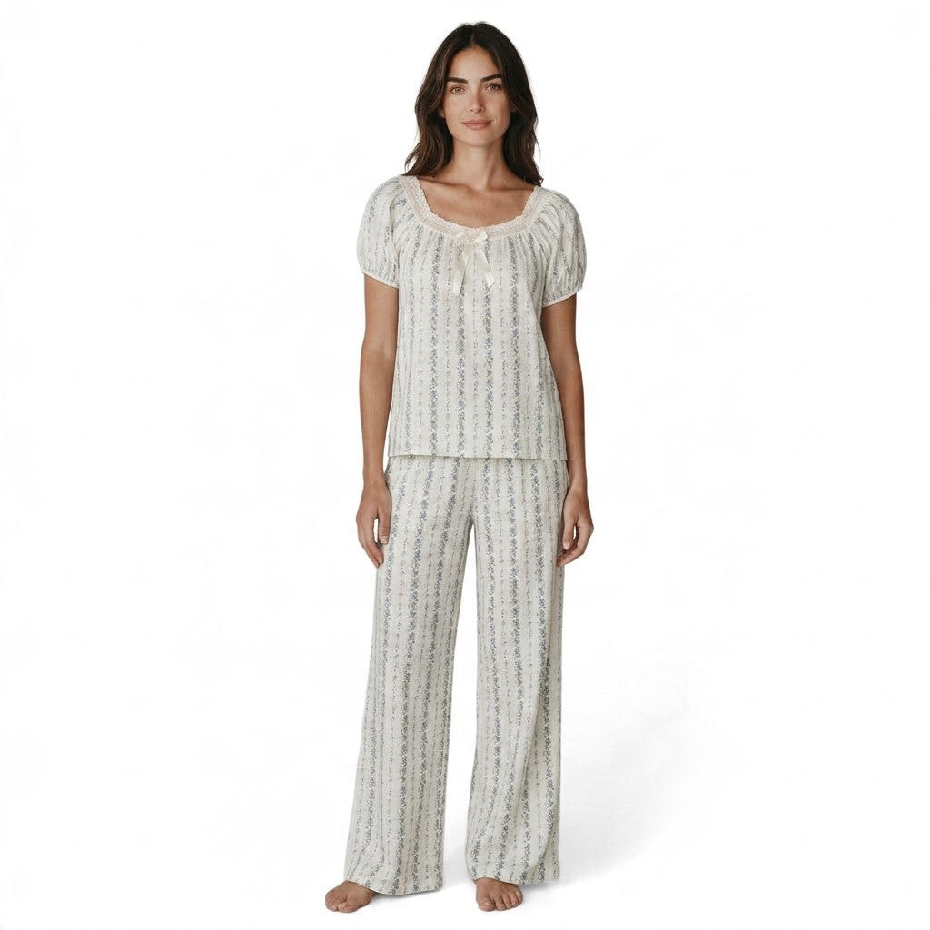 Model wearing a JOANNA FASHION floral print pajama set with puff sleeves, lace trim, and a ribbon bow detail.