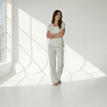 JOANNA FASHION floral pajama set with puff sleeves, lace trim, and ribbon bow on a woman in a bright studio setting.