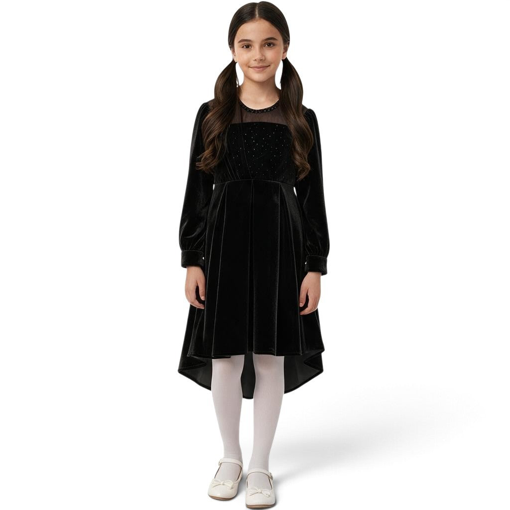 JOANNA FASHION girls black velvet high-low dress with sparkling bodice and sheer neckline worn with white tights