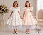 Two girls wearing JOANNA FASHION formal satin dresses with puff sleeves, pearl accents, and layered tulle skirts.
