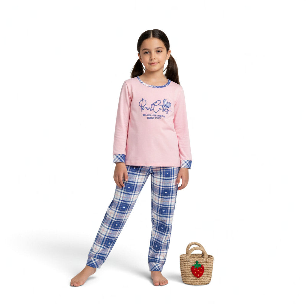 A young girl wearing a JOANNA FASHION pink long-sleeve pajama top with graphic print and blue plaid pajama pants.