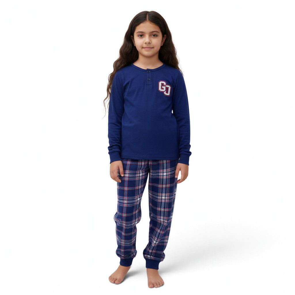 A young girl wearing a JOANNA FASHION blue long-sleeve henley pajama top with a collegiate logo and plaid pants.