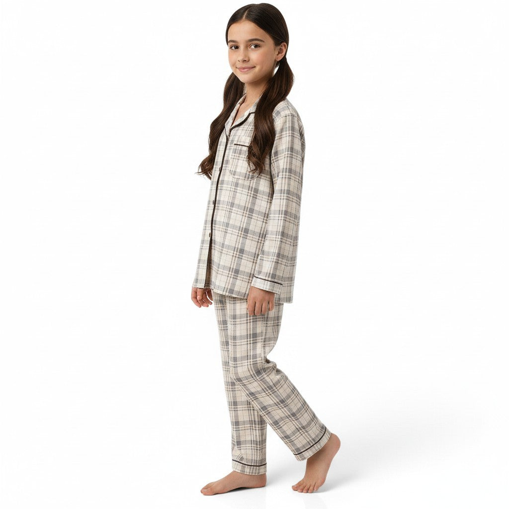 A young girl wearing a JOANNA FASHION neutral plaid button-down pajama set with contrast piping and a chest pocket.