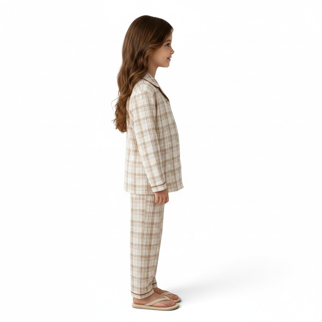A young girl wearing a JOANNA FASHION neutral plaid button-down pajama set with contrast piping, side view.