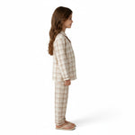 A young girl wearing a JOANNA FASHION neutral plaid button-down pajama set with contrast piping, side view.