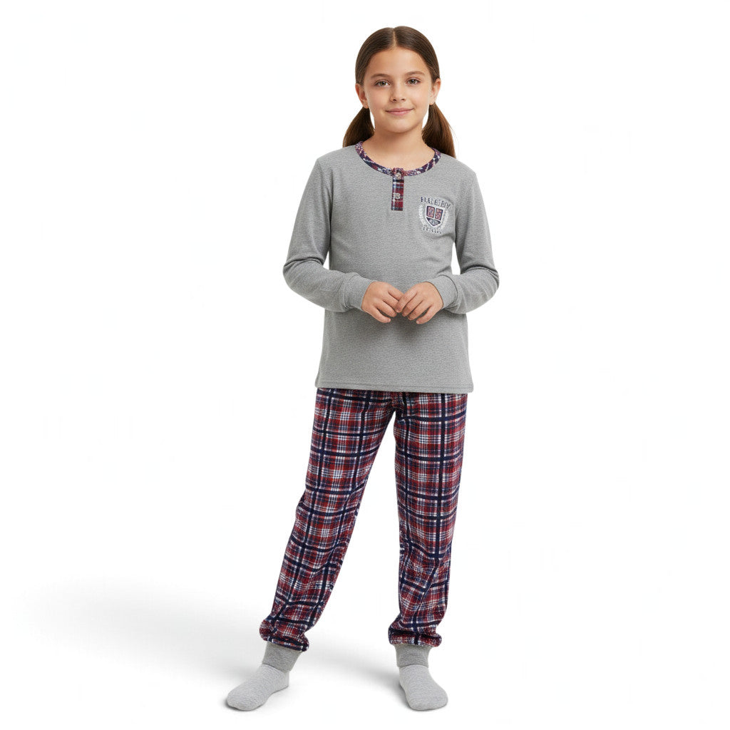 A girl wearing a JOANNA FASHION grey henley long-sleeve pajama top with rugby graphic and plaid flannel pants.