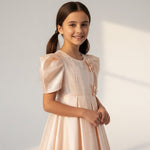 JOANNA FASHION girl in a pale pink satin formal dress with puff sleeves, pearl neckline, and floral appliqués.