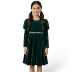 JOANNA FASHION girl wearing a dark green velvet dress with puff sleeves and pearl-style trim at the neckline and waist