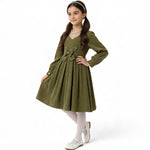 JOANNA FASHION olive green corduroy long sleeve dress with a pearl-embellished butterfly waist detail on a young girl.
