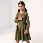 JOANNA FASHION olive green corduroy long sleeve dress with a floral appliqué on the chest worn by a young girl