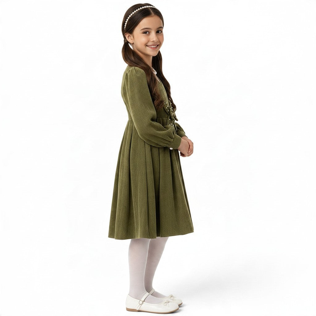 A girl wearing a JOANNA FASHION olive green corduroy long-sleeve pleated dress with a pearl-embellished butterfly waist.