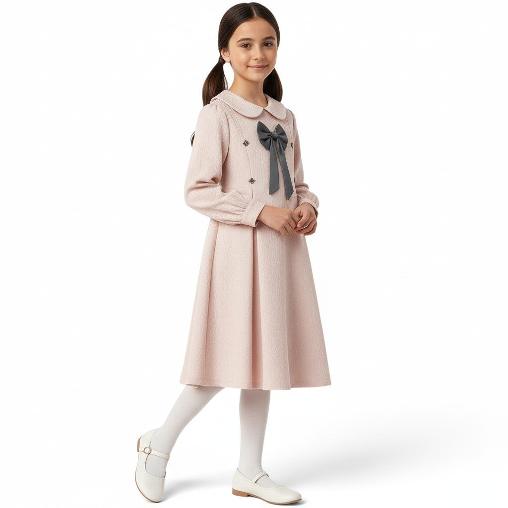 JOANNA FASHION girl wearing a pale pink long-sleeve dress with a Peter Pan collar, grey bow, and pleated skirt.