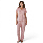 A woman wearing a JOANNA FASHION dusty pink two-piece pajama set with a V-neck button-down top and matching pants.