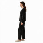 JOANNA FASHION black polka-dot long sleeve button-down pajama set with scalloped trim worn by a model, side view