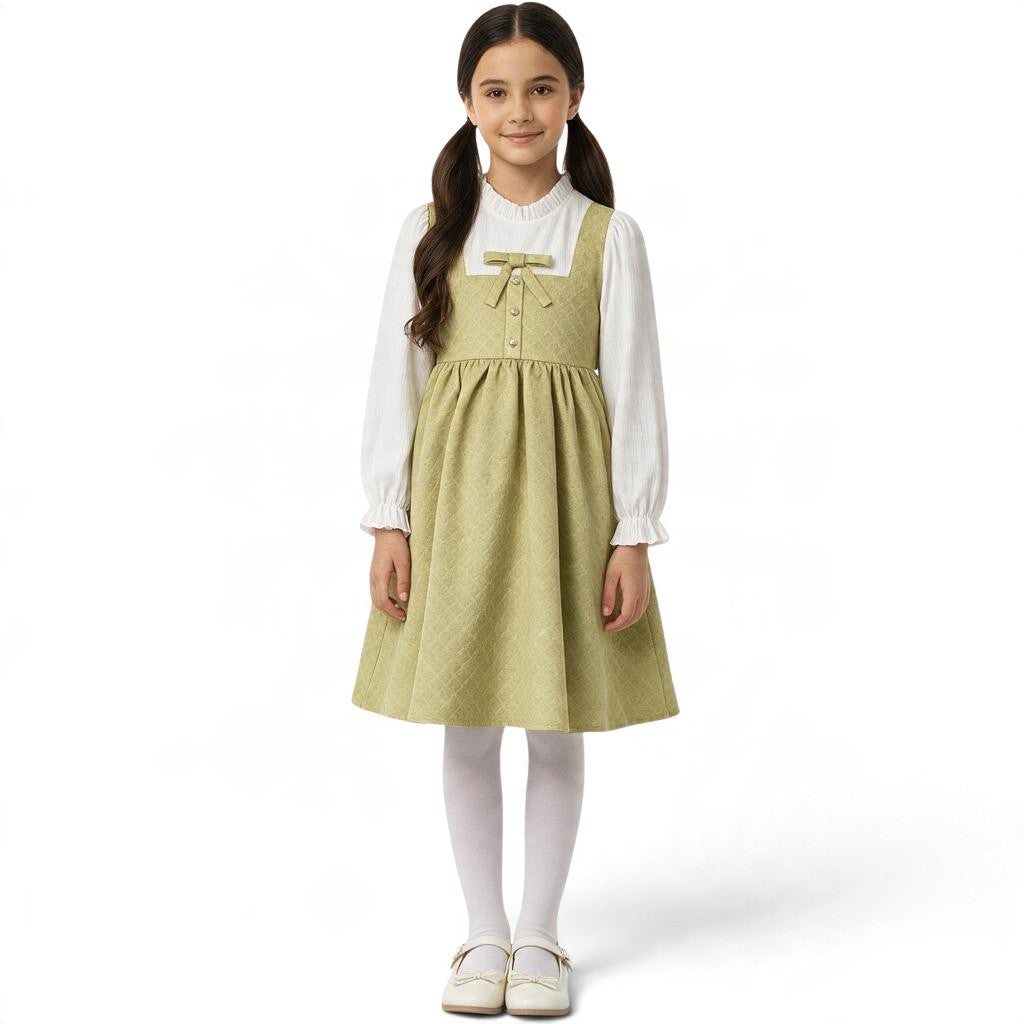 JOANNA FASHION sage green quilted pinafore dress with a bow detail, worn over a white blouse by a young girl.